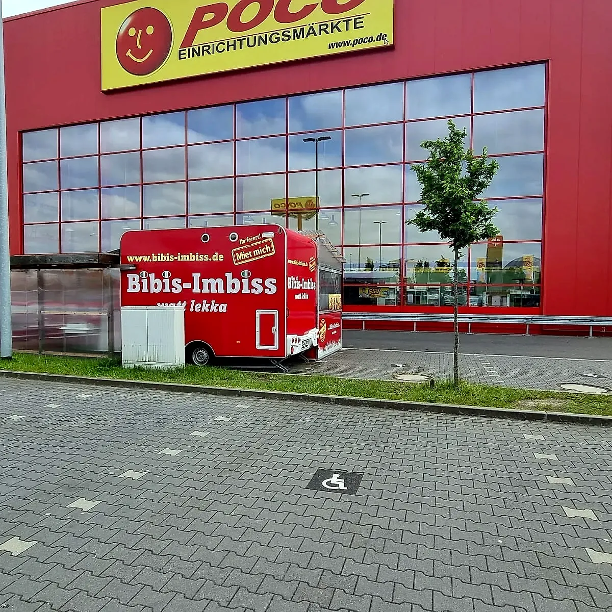 Der rote Imbisswagen von Bibis Imbiss vor dem Poco-Einrichtungsmarkt